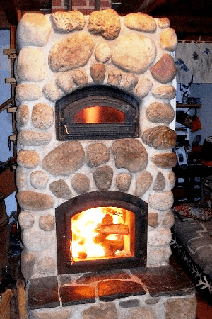 A bunch of bricks around a regular metal stove (wood burning